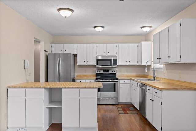 3554 Mountain Creek Rd, Chattanooga, TN 37415 - kitchen featuring stainless steel appliances, a sink, dark wood finished floors, white cabinetry, and a textured ceiling
