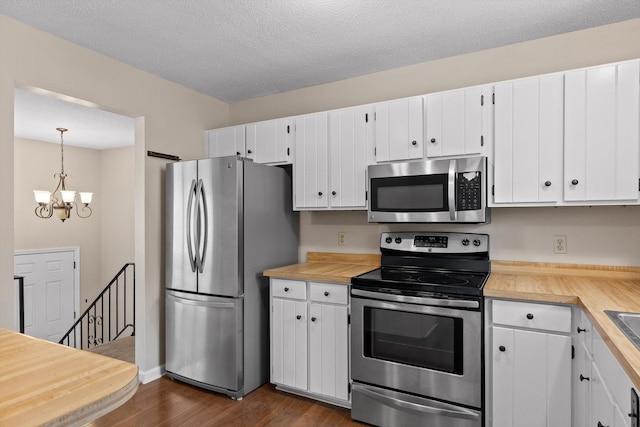 3554 Mountain Creek Rd, Chattanooga, TN 37415 - kitchen with appliances with stainless steel finishes, a chandelier, dark wood-style floors, white cabinets, and a textured ceiling