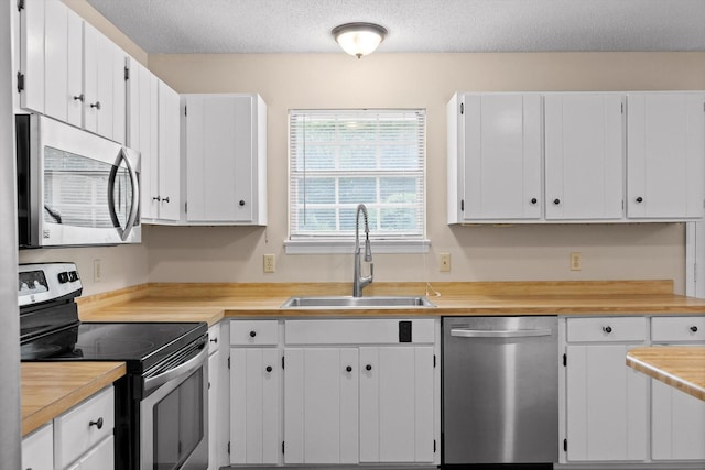 3554 Mountain Creek Rd, Chattanooga, TN 37415 - kitchen with stainless steel appliances, a sink, light countertops, white cabinets, and a textured ceiling
