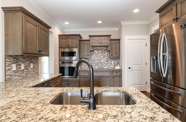 1130 Escalade Ct, Lascassas, TN 37085 - kitchen featuring stainless steel appliances, a sink, light stone countertops, tasteful backsplash, and ornamental molding