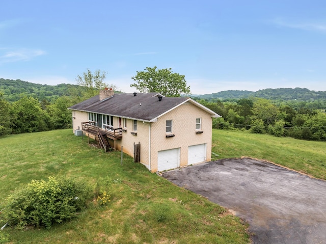 5307 Leipers Creek Rd, Franklin, TN 37064 - back of house with a chimney, a garage, a lawn, asphalt driveway, and a view of trees