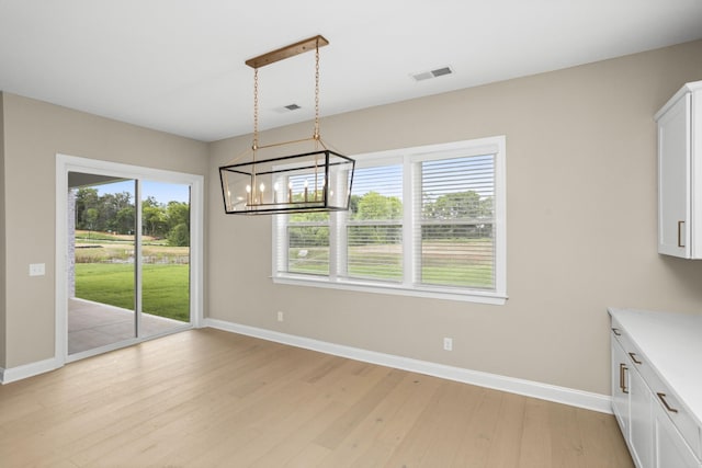 5971 Hunt Valley Dr, Spring Hill, TN 37174 - unfurnished dining area featuring healthy amount of natural light, light wood-style floors, and a chandelier