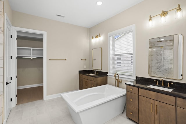 5971 Hunt Valley Dr, Spring Hill, TN 37174 - bathroom featuring a shower stall, two vanities, a freestanding tub, and a walk in closet
