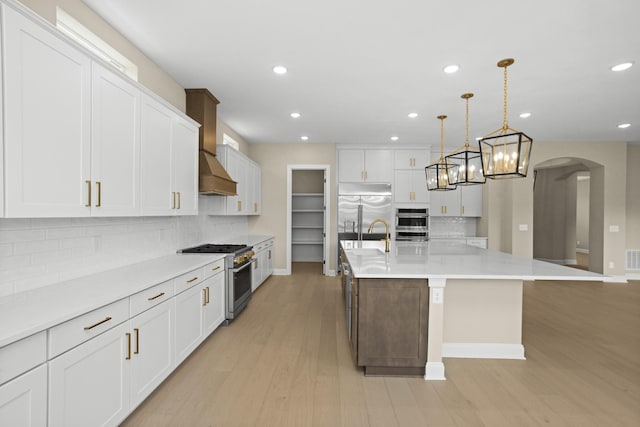 5971 Hunt Valley Dr, Spring Hill, TN 37174 - kitchen featuring high quality appliances, arched walkways, backsplash, white cabinetry, and recessed lighting