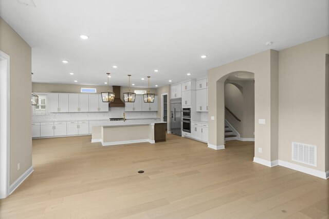 5971 Hunt Valley Dr, Spring Hill, TN 37174 - kitchen featuring wall chimney range hood, tasteful backsplash, light wood finished floors, light countertops, and recessed lighting