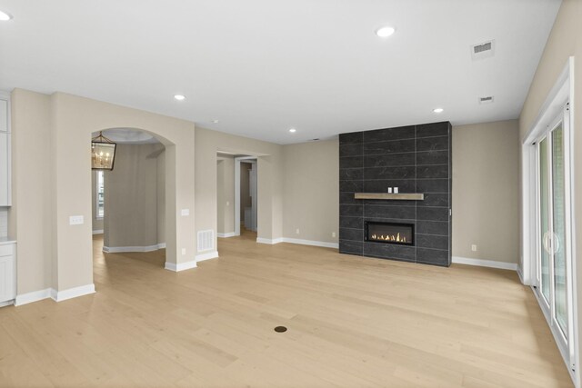 5971 Hunt Valley Dr, Spring Hill, TN 37174 - unfurnished living room with light wood finished floors, recessed lighting, arched walkways, and a fireplace