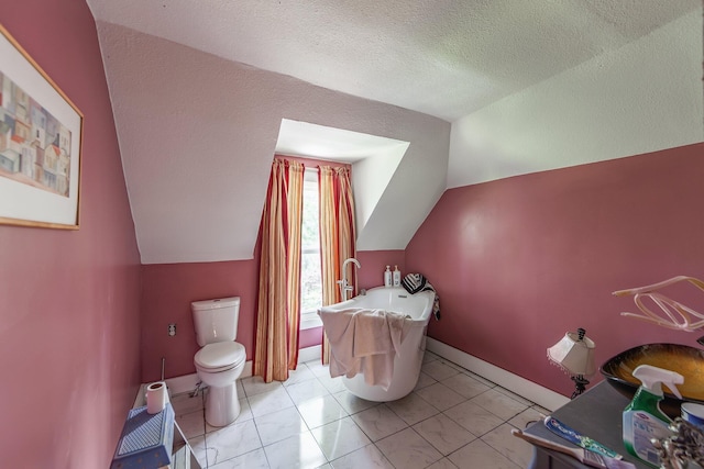 3396 Unionville Rd, Halls, TN 38040 - full bath with vaulted ceiling, a freestanding tub, toilet, and a textured ceiling