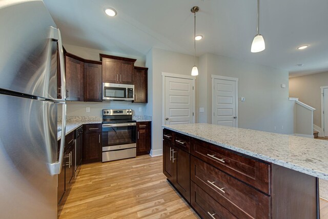 3010 Coriander Dr, Spring Hill, TN 37174 - kitchen with stainless steel appliances, light wood finished floors, dark brown cabinets, light stone counters, and hanging light fixtures