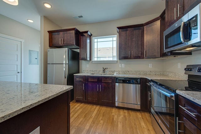 3010 Coriander Dr, Spring Hill, TN 37174 - kitchen featuring stainless steel appliances, a sink, light stone counters, light wood-type flooring, and electric panel