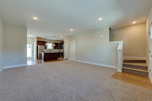 3010 Coriander Dr, Spring Hill, TN 37174 - unfurnished living room featuring light colored carpet, baseboards, stairway, and recessed lighting