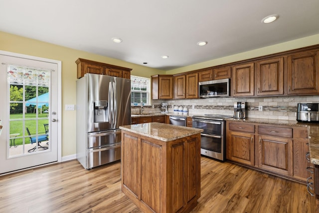 2917 York Rd, Pleasant View, TN 37146 - kitchen with appliances with stainless steel finishes, a sink, light wood-style flooring, a center island, and backsplash