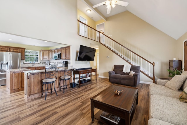 2917 York Rd, Pleasant View, TN 37146 - living room featuring light wood finished floors, stairs, a ceiling fan, high vaulted ceiling, and baseboards