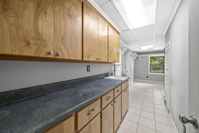255 Whispering Hills Dr, Dover, TN 37058 - kitchen featuring a sink, baseboards, light tile patterned floors, dark countertops, and a paneled ceiling