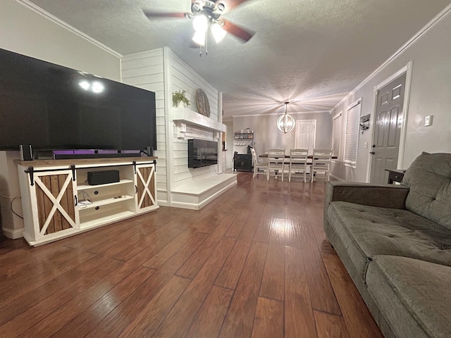 13276 Old Baxter Rd, Silver Point, TN 38582 - living area with a textured ceiling, ceiling fan, a fireplace, crown molding, and wood-type flooring