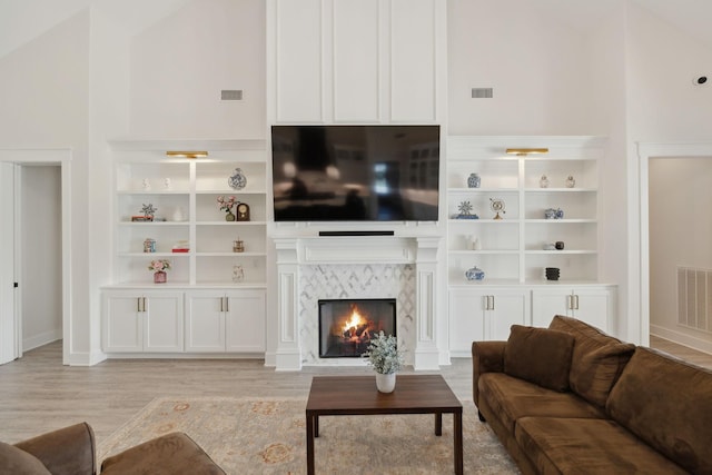 2648 Wilson Overall Rd, Murfreesboro, TN 37127 - living room featuring light wood-style flooring, a high end fireplace, baseboards, and built in shelves