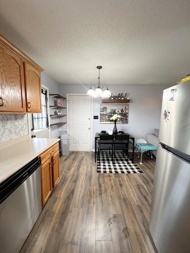 108 Josephines Ct, Oak Grove, KY 42262 - kitchen featuring appliances with stainless steel finishes, dark wood-type flooring, light countertops, a textured ceiling, and a chandelier