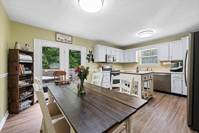 152 Scenic Cir, Ringgold, GA 30736 - dining space with light wood finished floors, a textured ceiling, and baseboards