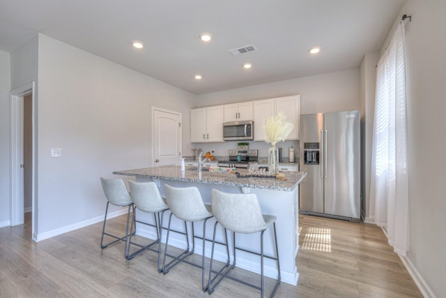336 Ryan Rd, Chapel Hill, TN 37034 - kitchen with stainless steel appliances, a center island with sink, a breakfast bar area, light wood finished floors, and recessed lighting
