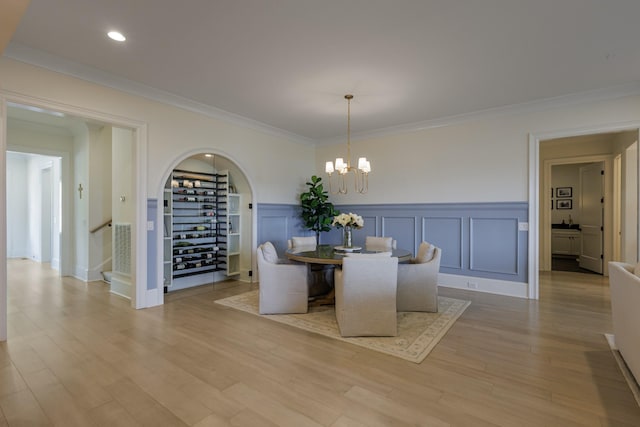 2026 Eliot Rd, Franklin, TN 37064 - dining room with arched walkways, a chandelier, ornamental molding, wainscoting, and light wood-style flooring