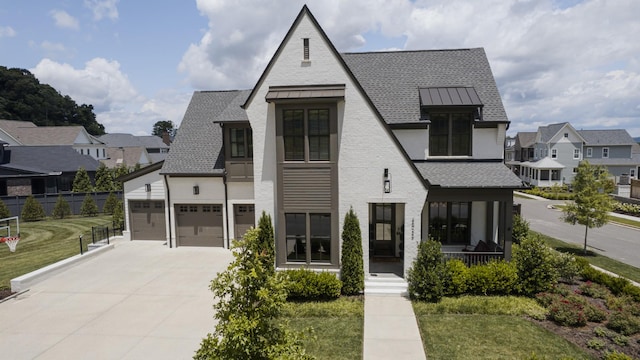 2026 Eliot Rd, Franklin, TN 37064 - view of front facade featuring concrete driveway, a residential view, a standing seam roof, stucco siding, and a shingled roof