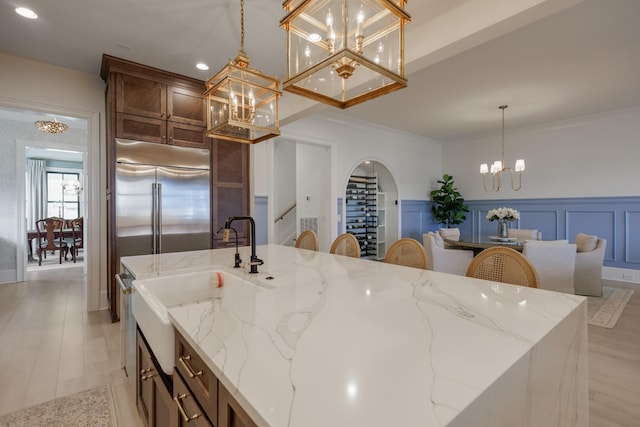 2026 Eliot Rd, Franklin, TN 37064 - kitchen featuring built in fridge, a chandelier, an island with sink, arched walkways, and pendant lighting