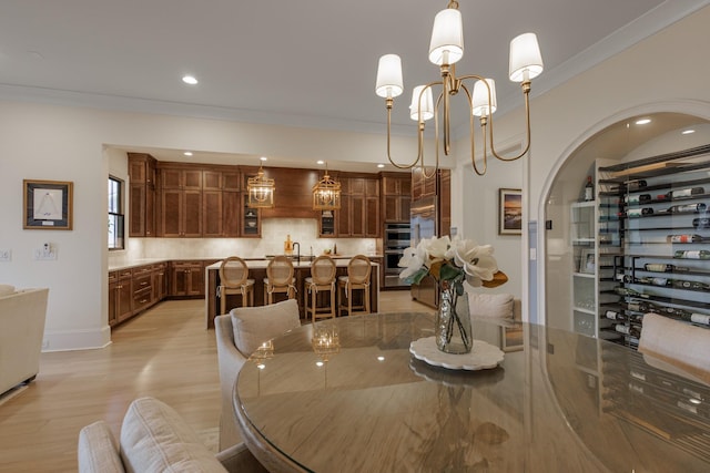2026 Eliot Rd, Franklin, TN 37064 - dining room featuring light wood-style flooring, ornamental molding, a chandelier, recessed lighting, and arched walkways