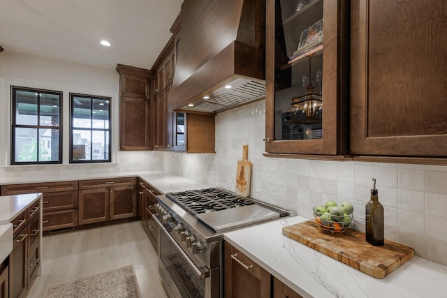 2026 Eliot Rd, Franklin, TN 37064 - kitchen with double oven range, wall chimney range hood, decorative backsplash, light stone countertops, and glass insert cabinets
