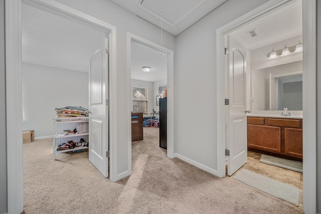 4113 Saddlecreek Way, Antioch, TN 37013 - hallway featuring attic access, light carpet, baseboards, and a sink