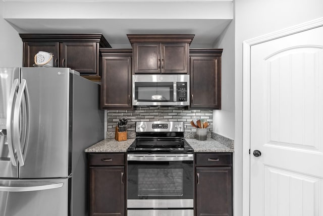 324 Kildeer Dr, Clarksville, TN 37040 - kitchen with stainless steel appliances, dark brown cabinetry, decorative backsplash, and light stone countertops