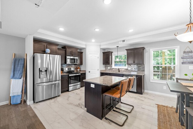324 Kildeer Dr, Clarksville, TN 37040 - kitchen featuring stainless steel appliances, crown molding, dark brown cabinetry, a sink, and decorative backsplash