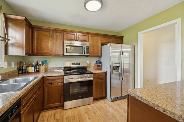 1809 Mosley Ferry Rd, Chapmansboro, TN 37035 - kitchen with stainless steel appliances, light wood-style floors, a sink, and light countertops