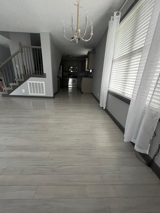 117 Sparrow Ln, Dover, TN 37058 - unfurnished living room featuring a chandelier, light wood-style floors, stairs, and baseboards