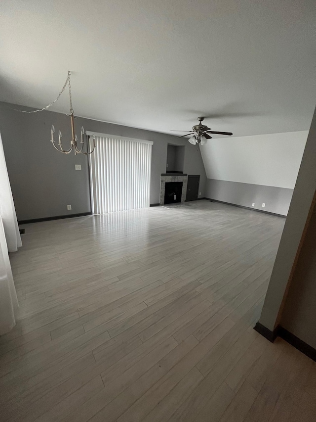 117 Sparrow Ln, Dover, TN 37058 - unfurnished living room with a chandelier, ceiling fan, wood finished floors, baseboards, and lofted ceiling
