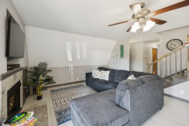 117 Sparrow Ln, Dover, TN 37058 - living area with a ceiling fan, stairs, a tile fireplace, and wood finished floors