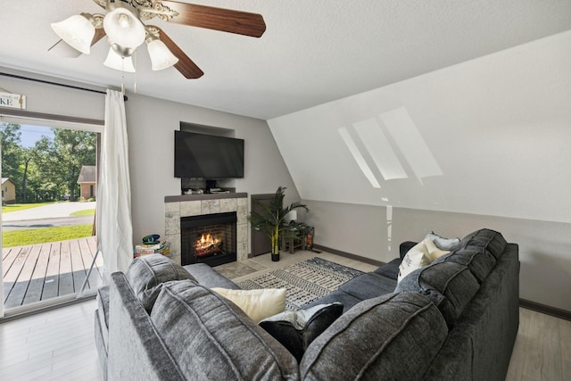 117 Sparrow Ln, Dover, TN 37058 - living area featuring ceiling fan, wood finished floors, a skylight, a fireplace, and vaulted ceiling