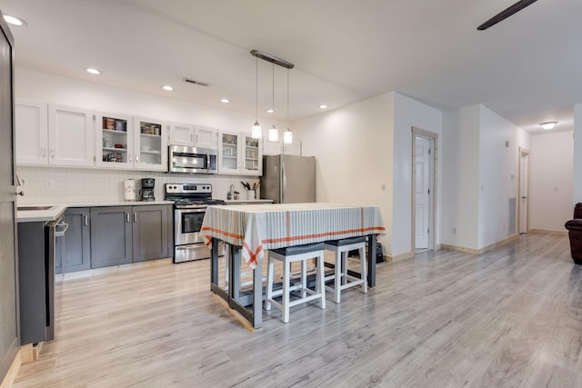 7872 Oscar Green Rd, Primm Springs, TN 38476 - kitchen with appliances with stainless steel finishes, light wood-style flooring, backsplash, light countertops, and recessed lighting