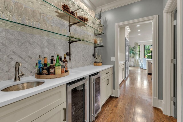 238 Pelham Dr, Brentwood, TN 37027 - indoor dry bar featuring wine cooler, crown molding, decorative backsplash, wood finished floors, and high end refrigerator