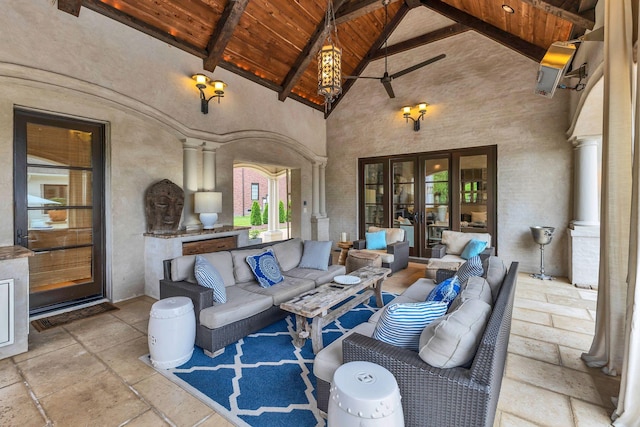238 Pelham Dr, Brentwood, TN 37027 - living room featuring wood ceiling with exposed beams, stone tile flooring, decorative columns, high vaulted ceiling, and a ceiling fan