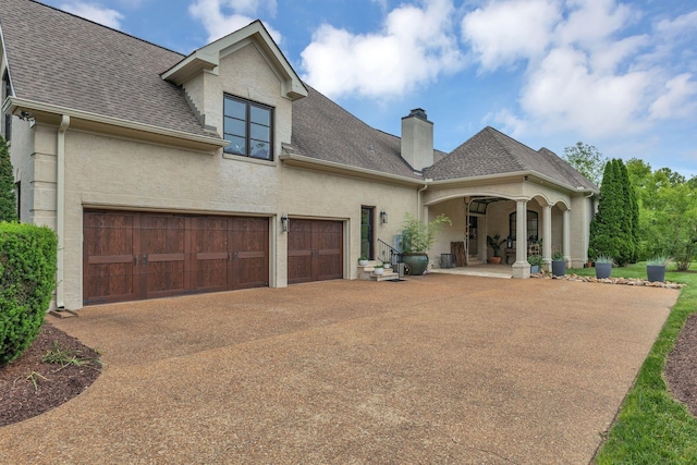 238 Pelham Dr, Brentwood, TN 37027 - view of front of home with driveway, a shingled roof, a chimney, and stucco siding