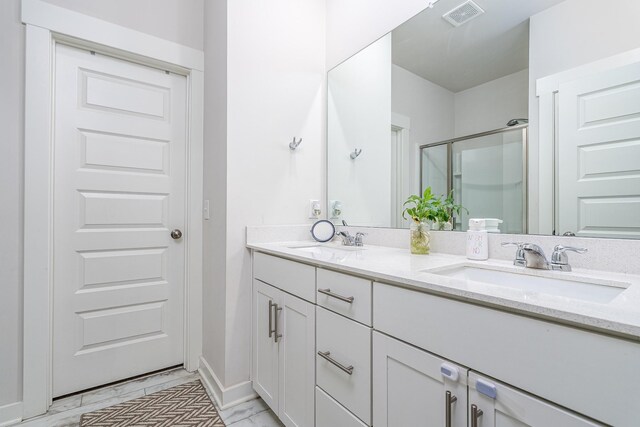 604 Birdie Dr, Spring Hill, TN 37174 - bathroom featuring double vanity, marble look tiles, a shower stall, and baseboards