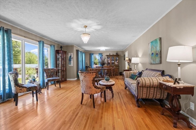 210 Lankford St, Bruceton, TN 38317 - living room featuring light wood-style flooring, a textured ceiling, crown molding, and baseboards