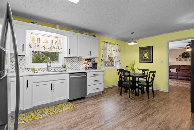 210 Lankford St, Bruceton, TN 38317 - kitchen with stainless steel appliances, a sink, light wood-type flooring, backsplash, and light countertops