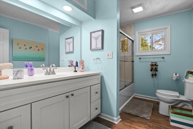 210 Lankford St, Bruceton, TN 38317 - full bathroom with toilet, vanity, wood finished floors, bath / shower combo with glass door, and baseboards