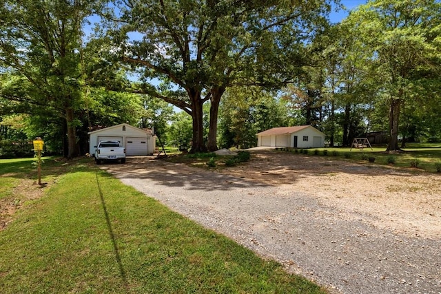 210 Lankford St, Bruceton, TN 38317 - view of front of property featuring a detached garage, an outbuilding, and view of wooded area