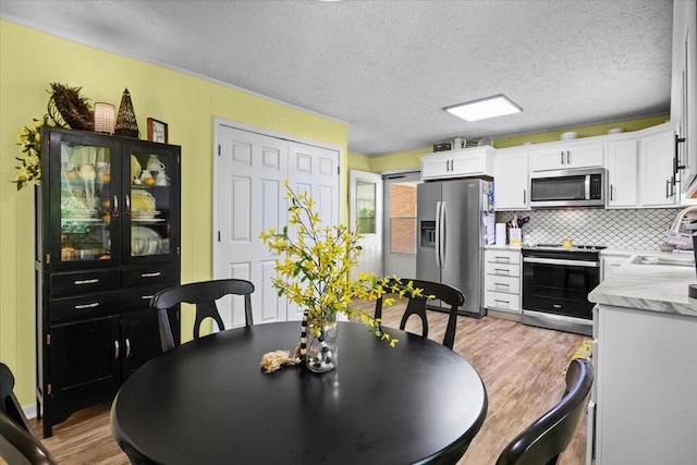 210 Lankford St, Bruceton, TN 38317 - dining room featuring light wood-style flooring and a textured ceiling