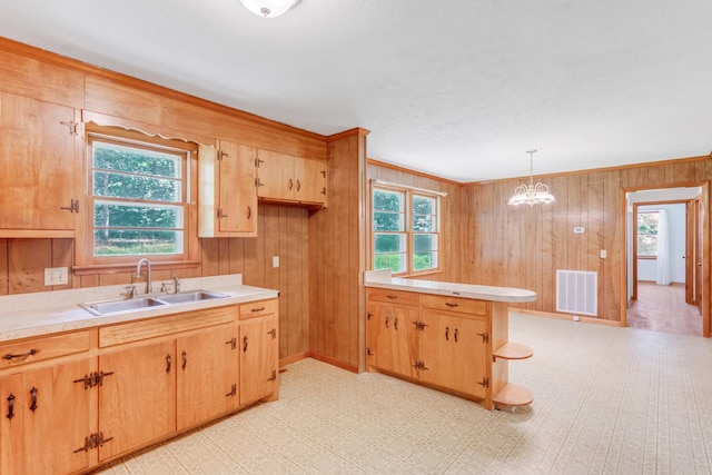 7111 Harrison Dr, Fairview, TN 37062 - kitchen with light countertops, wood walls, a peninsula, decorative light fixtures, and a chandelier
