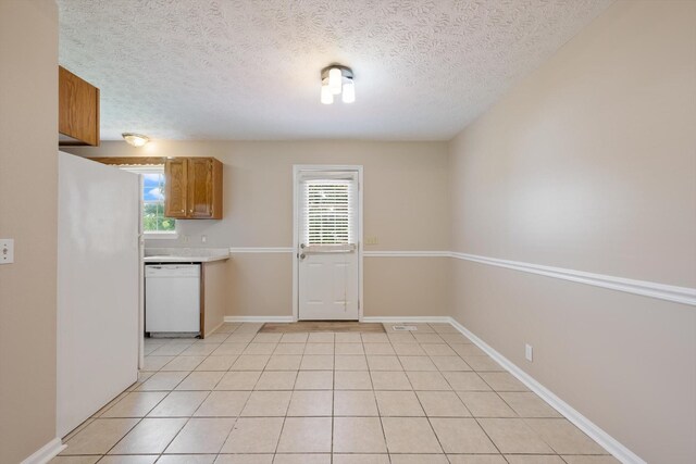 104 Hillcreek Ct, Portland, TN 37148 - kitchen featuring dishwasher, a textured ceiling, light tile patterned flooring, light countertops, and brown cabinets