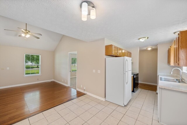 104 Hillcreek Ct, Portland, TN 37148 - kitchen featuring freestanding refrigerator, a sink, light tile patterned floors, light countertops, and lofted ceiling