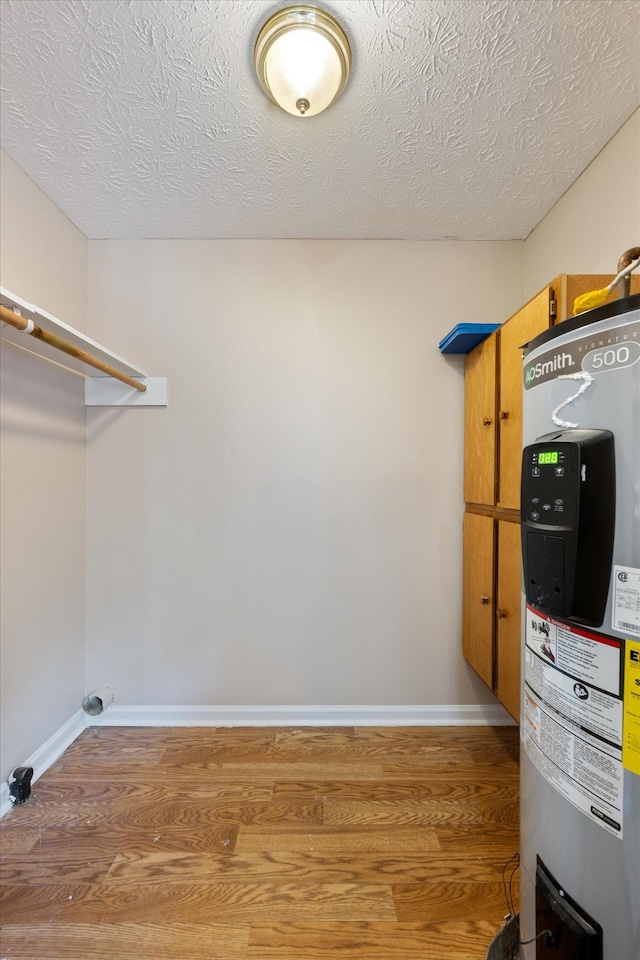 104 Hillcreek Ct, Portland, TN 37148 - laundry area featuring electric water heater, wood finished floors, baseboards, and a textured ceiling