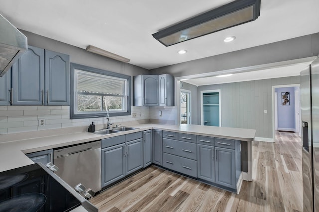 101 Walnut St, Smyrna, TN 37167 - kitchen with a sink, stainless steel appliances, a peninsula, light wood-type flooring, and decorative backsplash